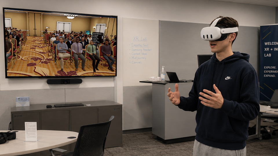 Learner wearing a Meta Quest headset while practicing a presentation in a college VR lab